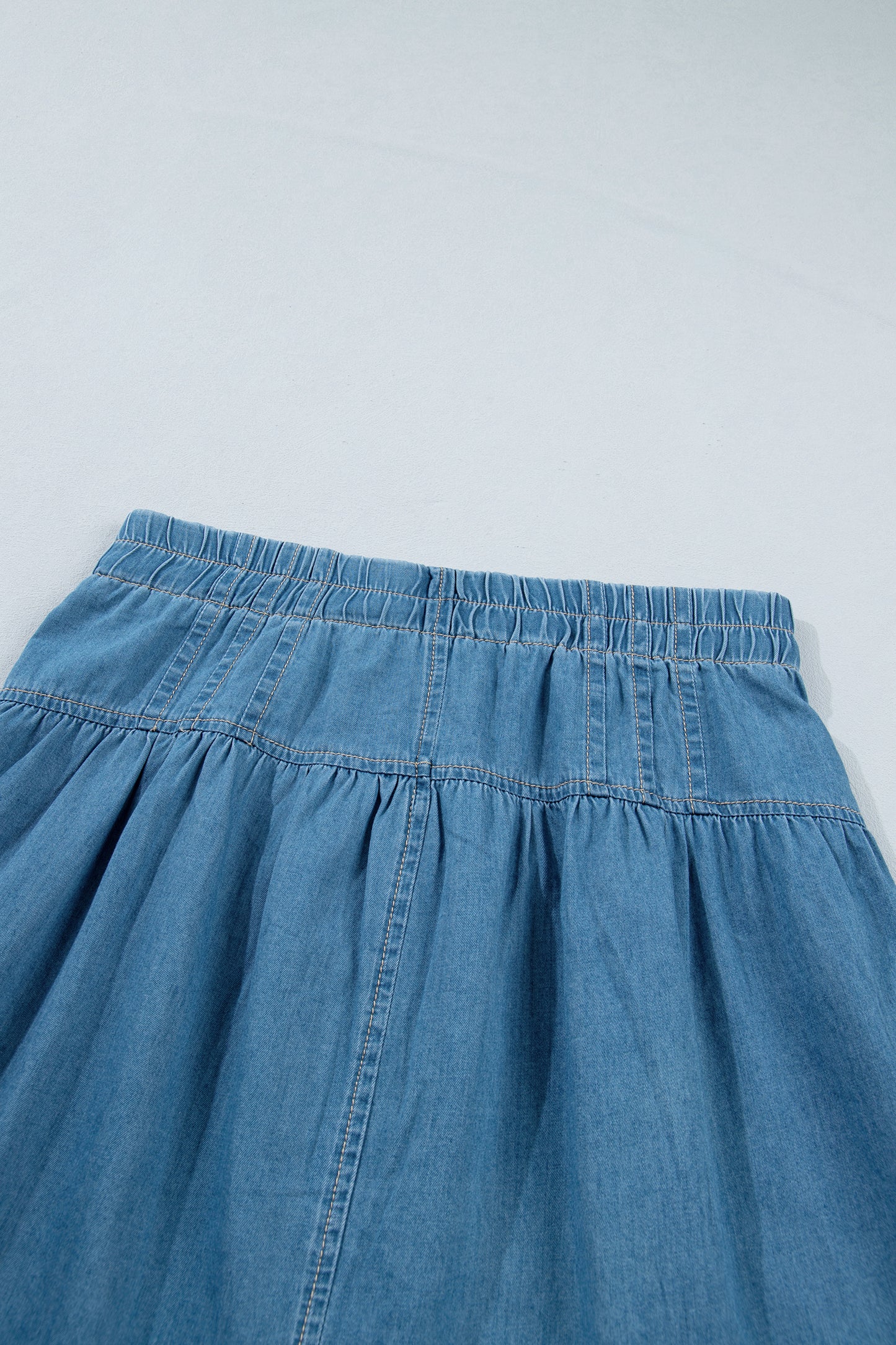 Minifalda vaquera celeste con botones, plisada, de talle alto con cordón