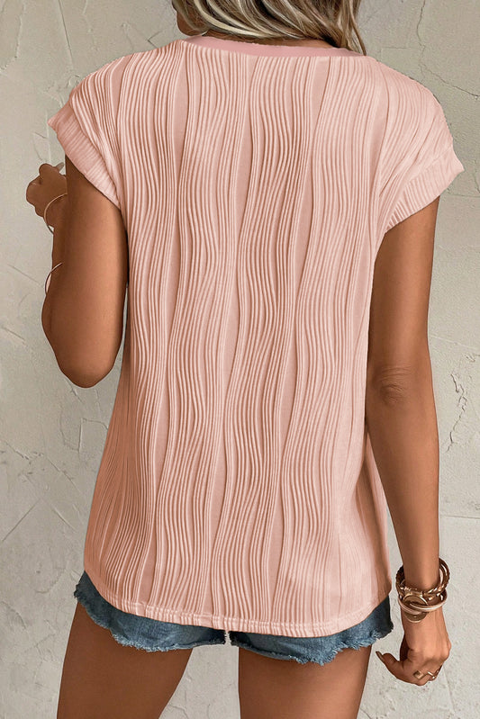 Camiseta rosa con cuello de pico, botones y textura ondulada