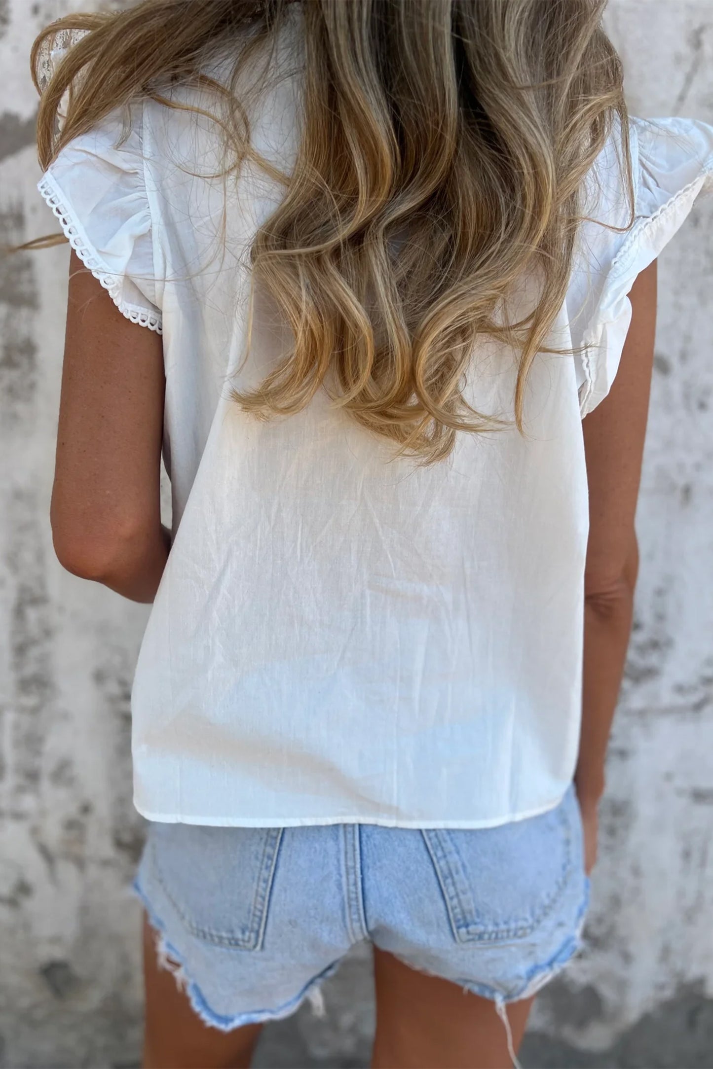 Blusa con detalle de encaje blanco, manga con volantes y cuello redondo plisado