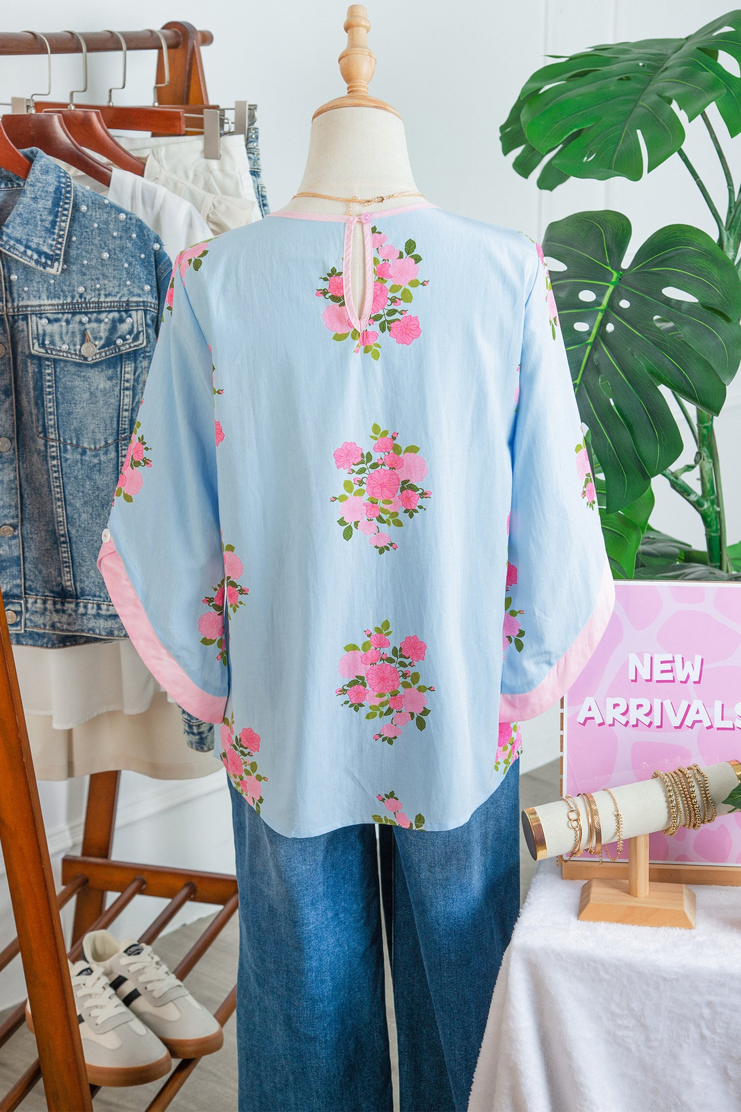 Blusa de manga 3/4 con cuello redondo, botones en los puños y estampado floral azul cielo