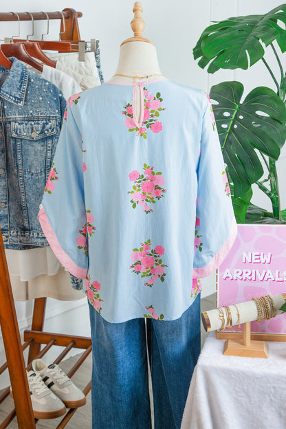 Blusa de manga 3/4 con cuello redondo, botones en los puños y estampado floral azul cielo