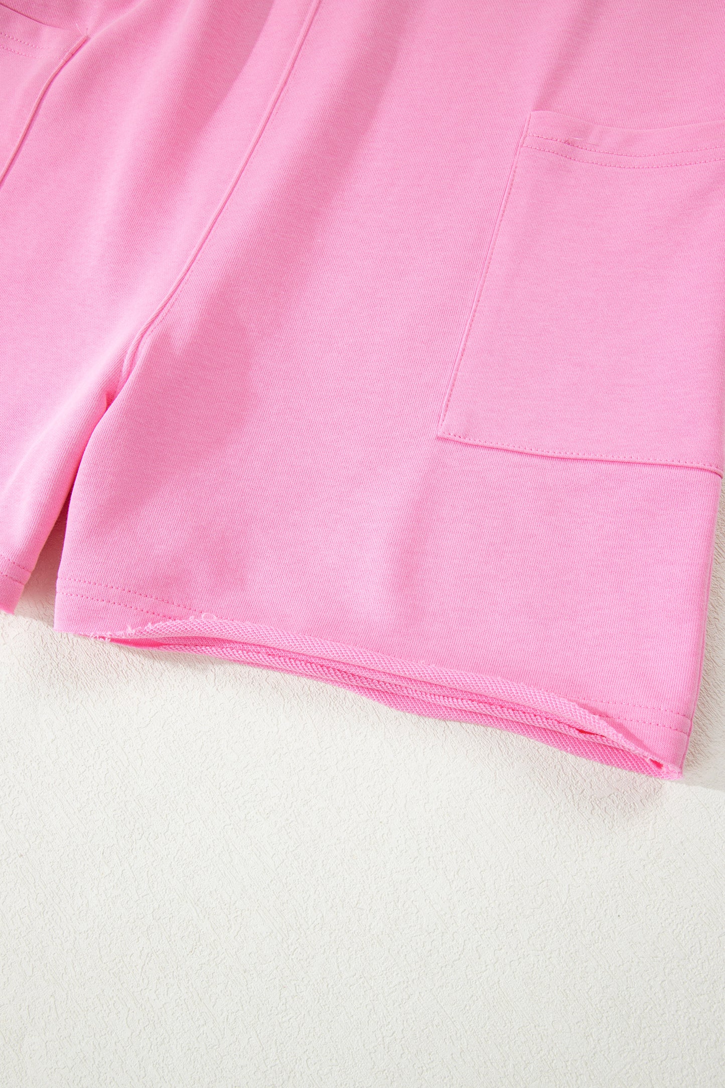 Mameluco suelto rosa de color sólido con bolsillo y dobladillo sin rematar de media manga