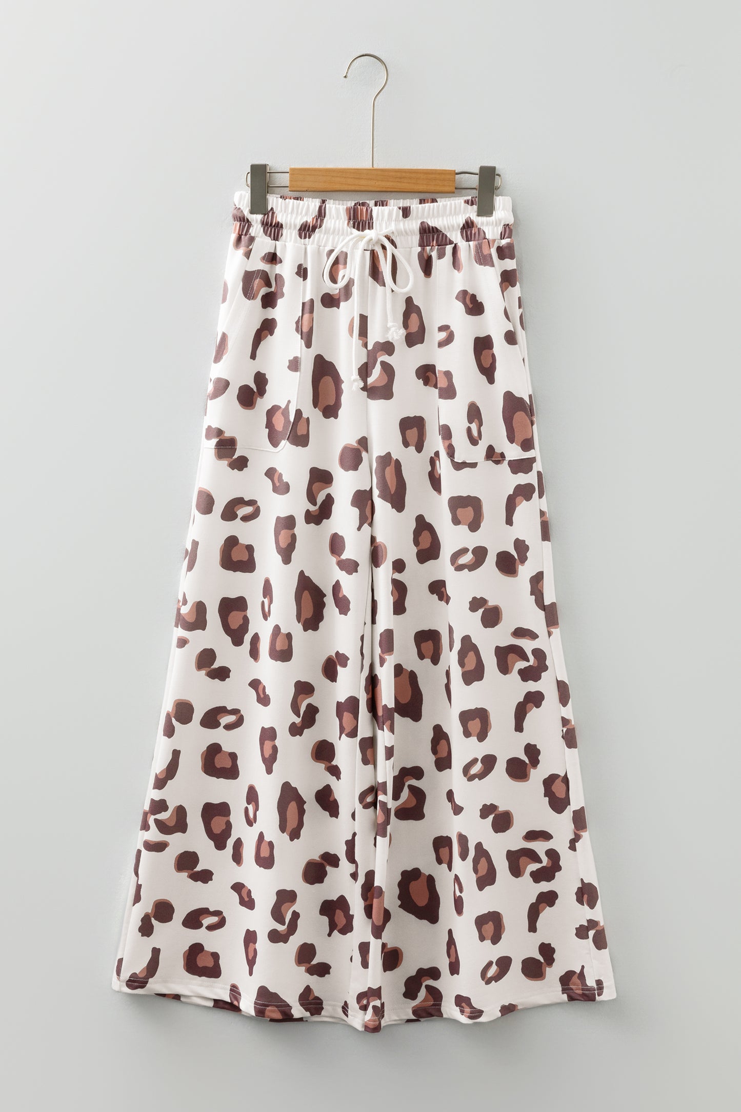 Pantalones sueltos de chándal color beige con estampado de leopardo y bolsillos de parche