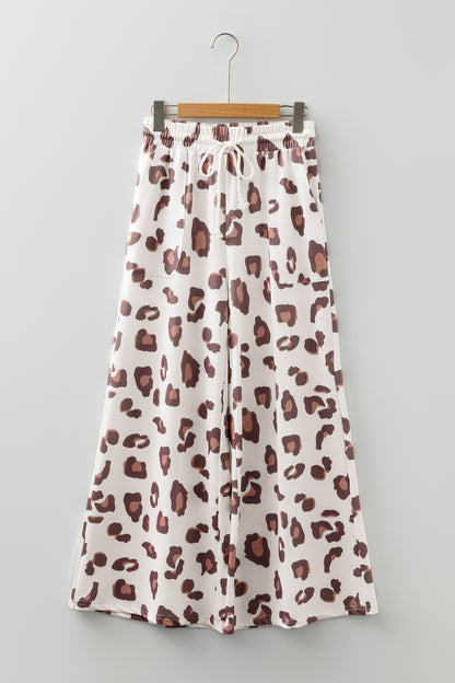 Pantalones sueltos de chándal color beige con estampado de leopardo y bolsillos de parche