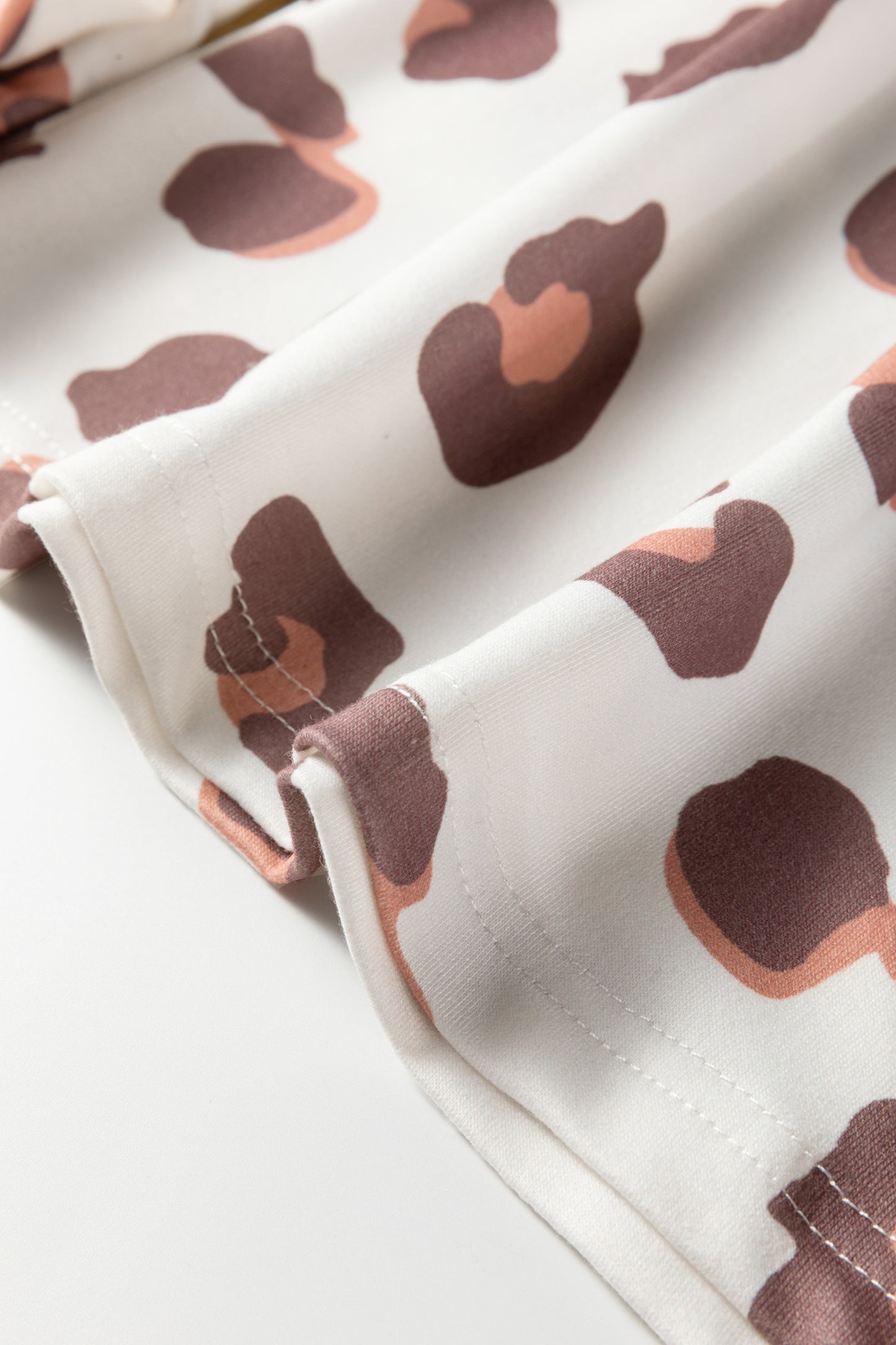 Pantalones sueltos de chándal color beige con estampado de leopardo y bolsillos de parche