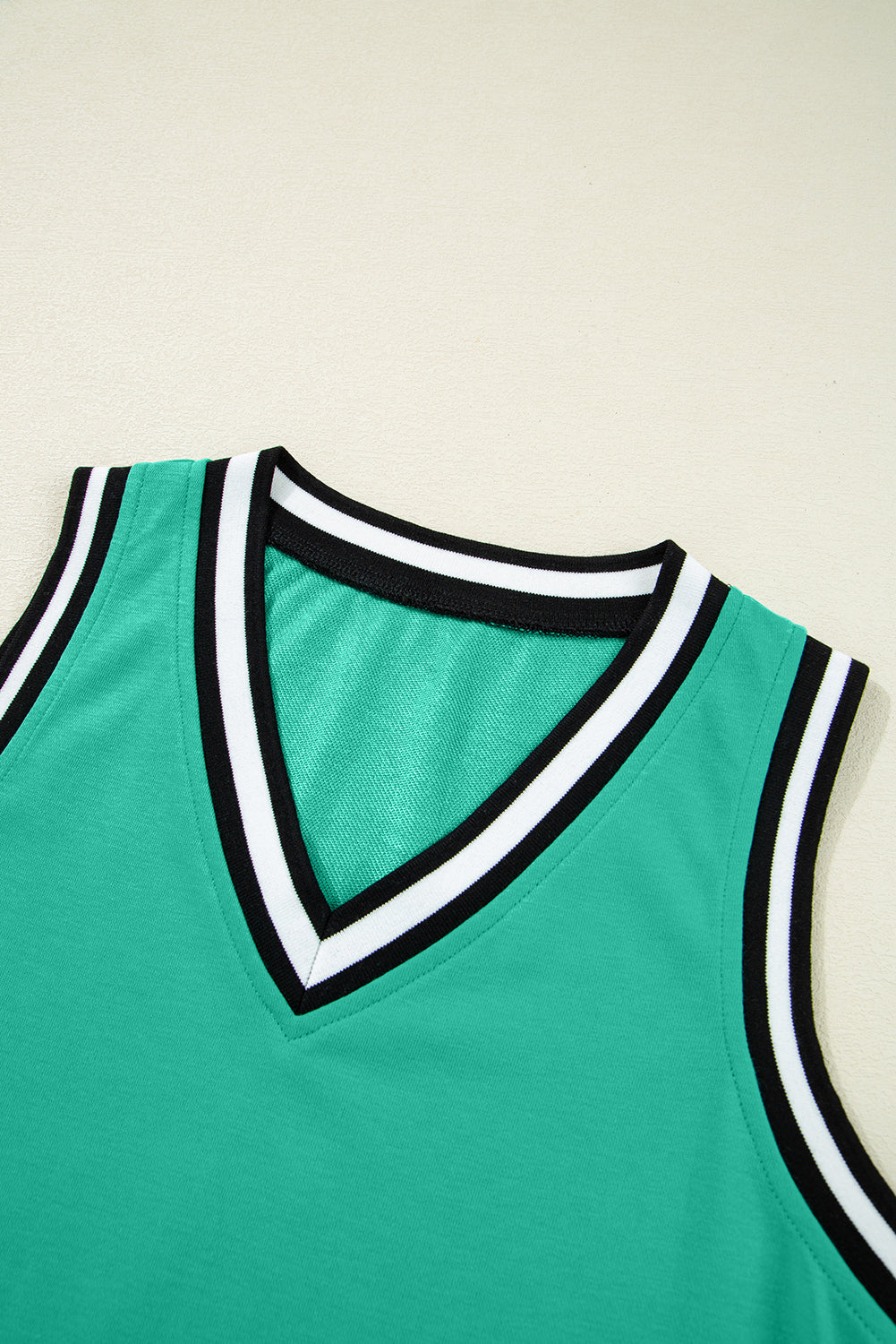 Minivestido con cuello en V, sin mangas, de color verde menta con ribete de contraste.