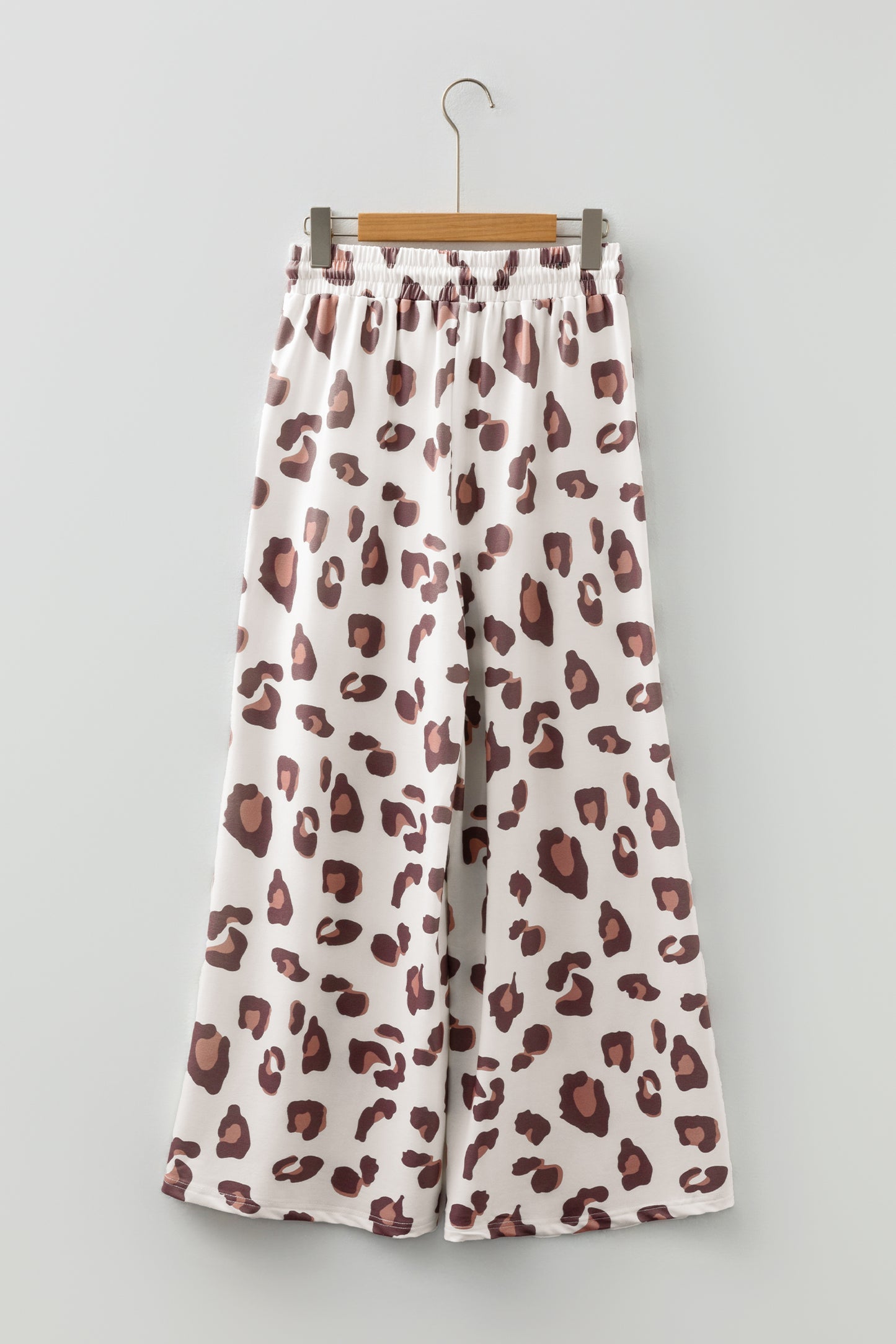 Pantalones sueltos de chándal color beige con estampado de leopardo y bolsillos de parche