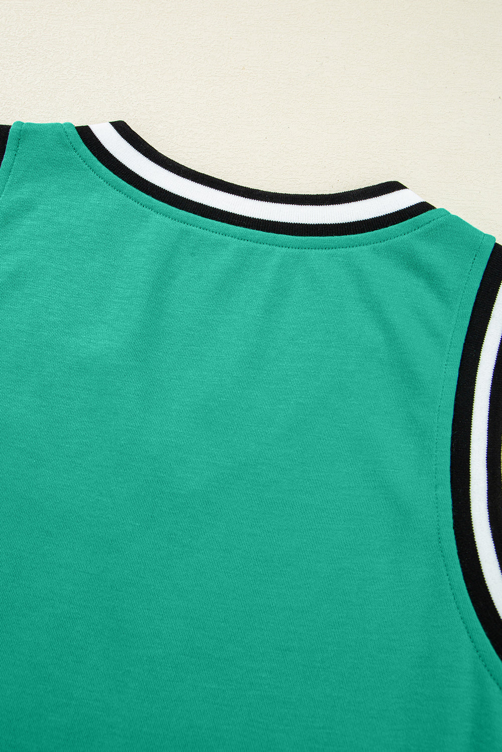 Minivestido con cuello en V, sin mangas, de color verde menta con ribete de contraste.