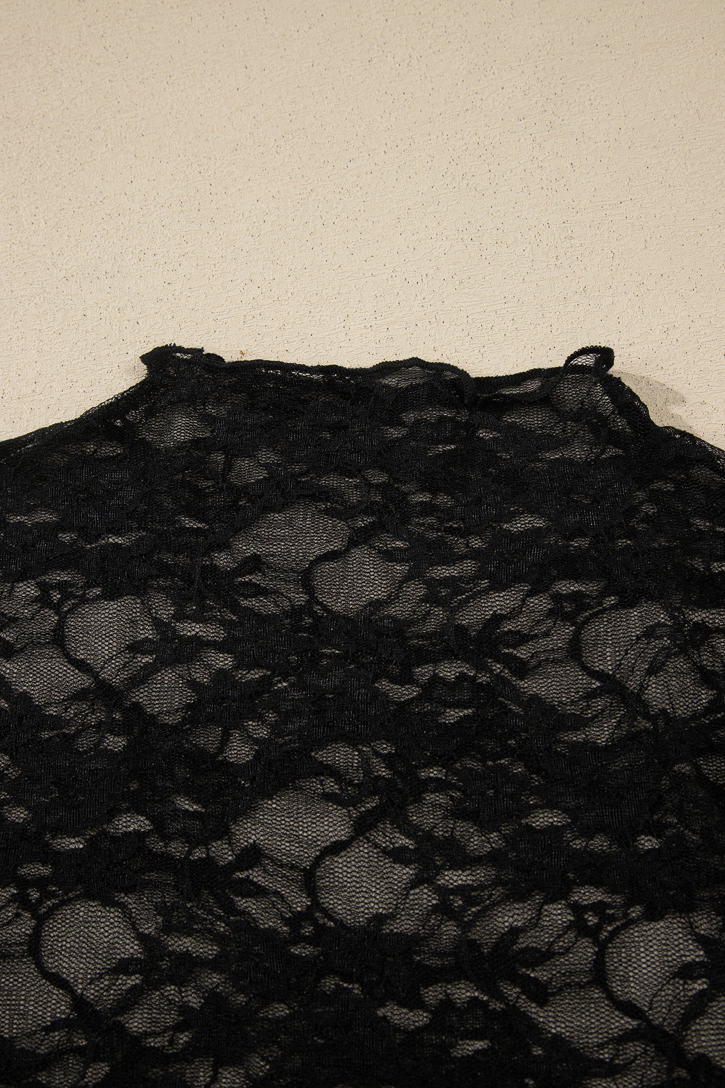 Top de manga larga de encaje floral semitransparente negro con cuello simulado y dobladillo ondulado