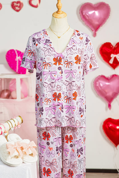 Pijama de pantalón corto con botones, lazos diversos, estampado y ribete en contraste en color rosa