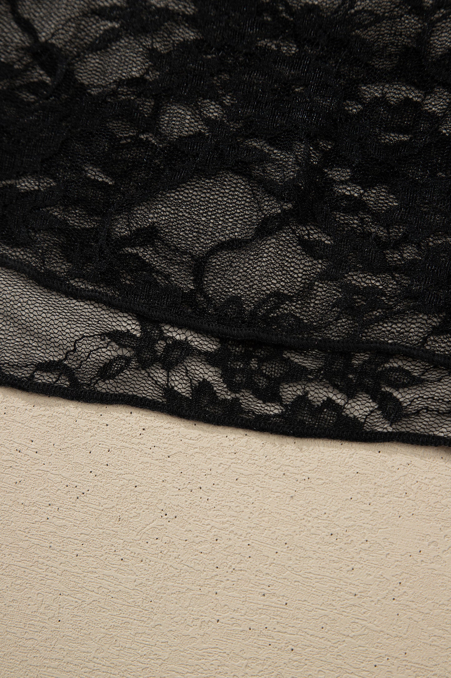 Top de manga larga de encaje floral semitransparente negro con cuello simulado y dobladillo ondulado