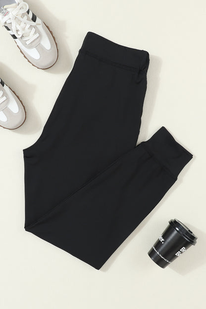 Pantalones jogger negros con cordón, cintura elástica y bolsillos