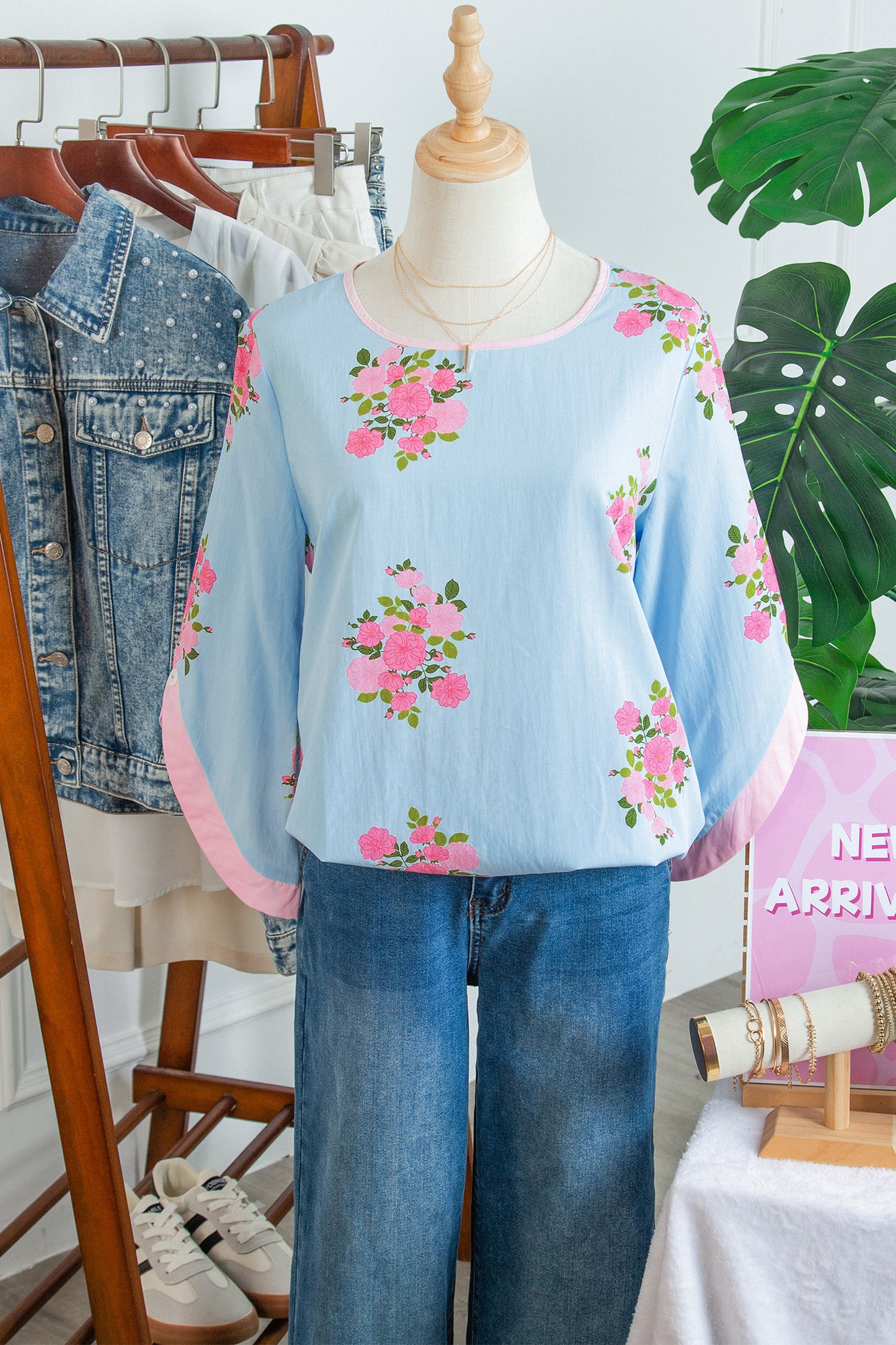 Blusa de manga 3/4 con cuello redondo, botones en los puños y estampado floral azul cielo