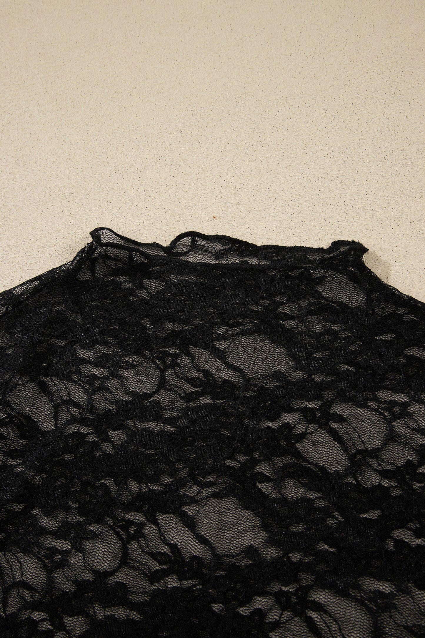 Top de manga larga de encaje floral semitransparente negro con cuello simulado y dobladillo ondulado