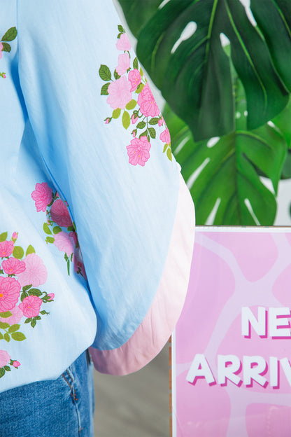 Blusa de manga 3/4 con cuello redondo, botones en los puños y estampado floral azul cielo