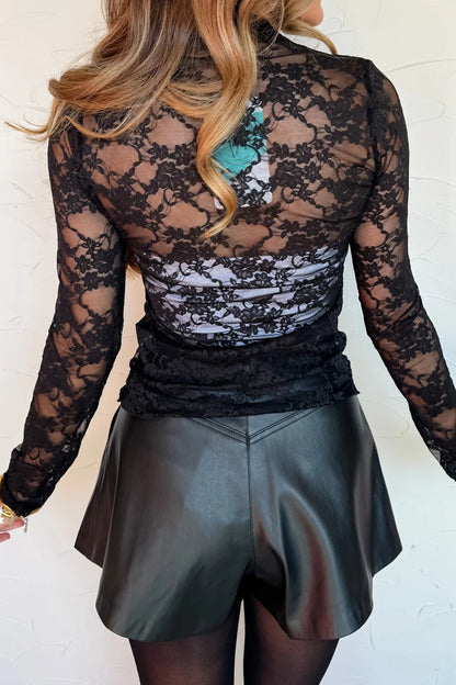 Top de manga larga de encaje floral semitransparente negro con cuello simulado y dobladillo ondulado