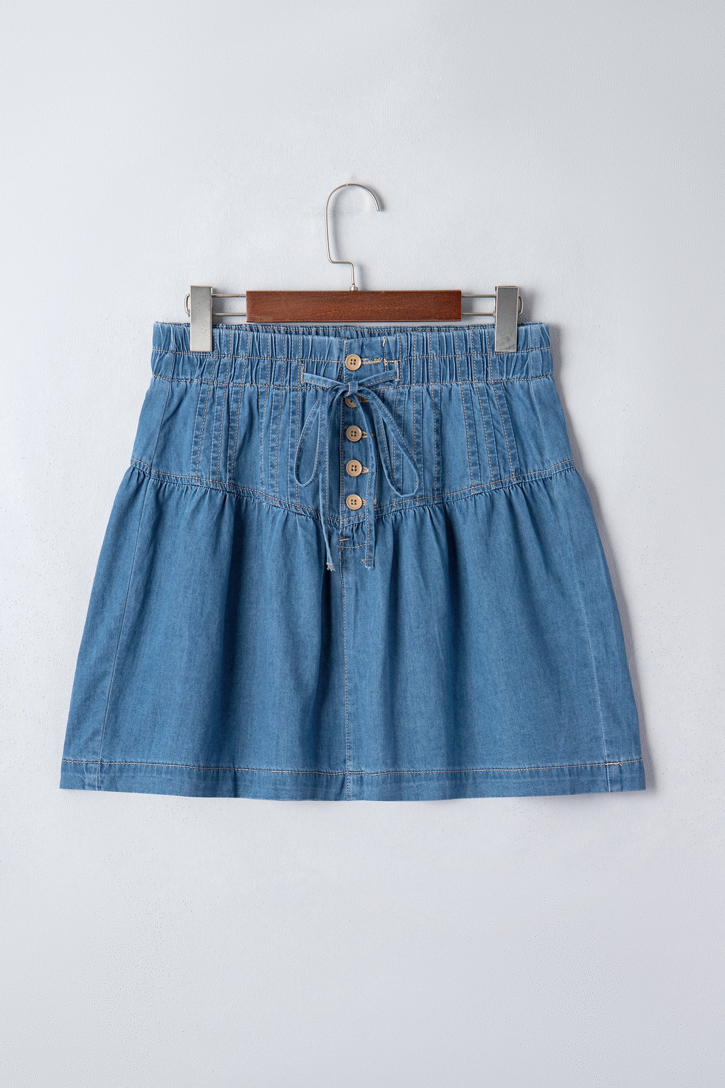 Minifalda vaquera celeste con botones, plisada, de talle alto con cordón