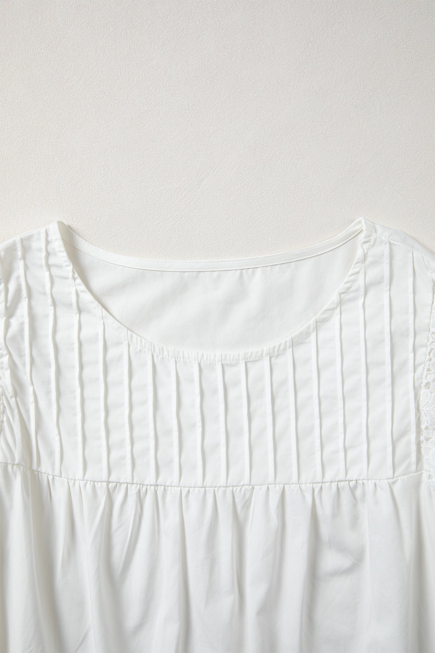 Blusa con detalle de encaje blanco, manga con volantes y cuello redondo plisado